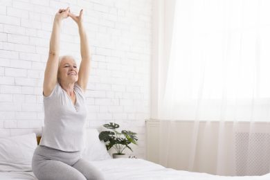 Active senior lady stretching her body at home